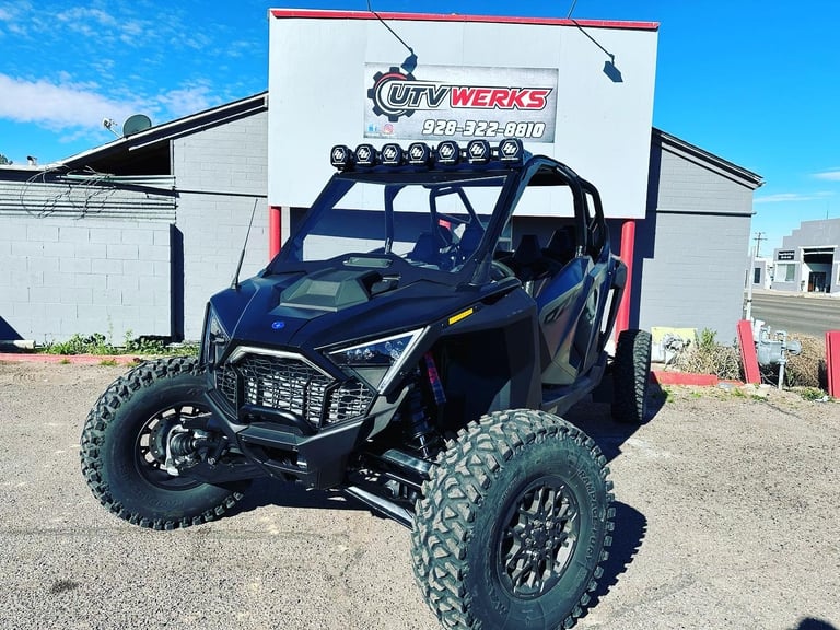 Dark blue lifted off-road UTV with roof rack and light bar parked in front of City Werks storage unit