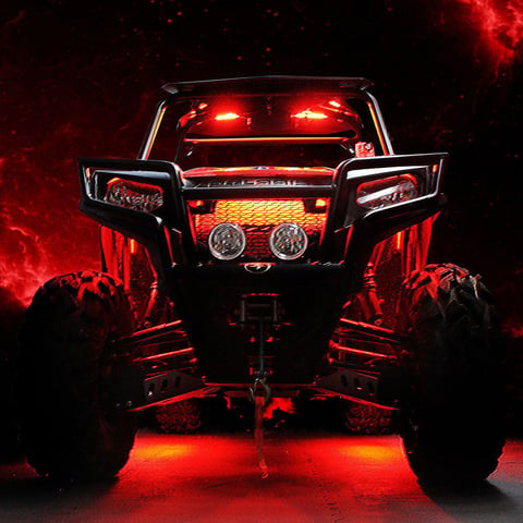 Front view of a red and black UTV with glowing red LED lights against a dark background with red atmospheric effects