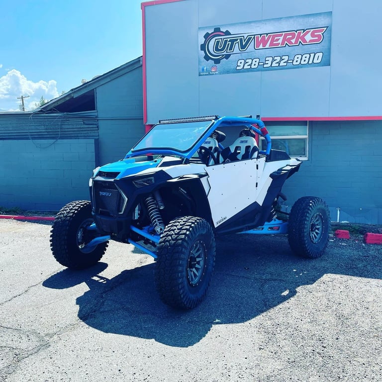 Blue and white UTV parked in front of City Werks shop with pink and blue signage