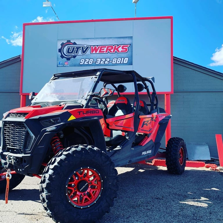 Red and black off-road buggy displayed in front of City Werks shop with large signage