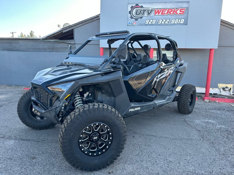 Black Polaris RZR side-by-side off-road vehicle with custom wheels displayed at UTV Werks dealership