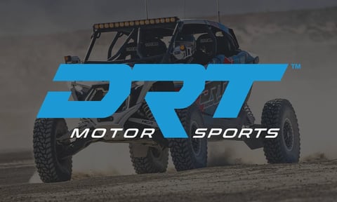 DRT logo overlay on a rugged off-road vehicle with large tires in a desert setting